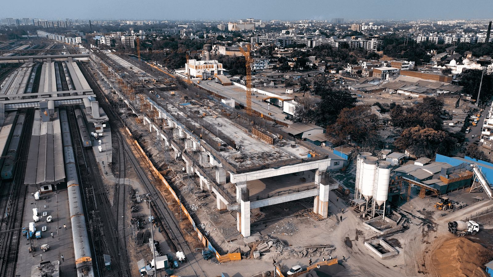 Aerial view of the elevated High Speed Rail station under construction at Sabarmati, Ahmedabad, beside the existing railway platforms