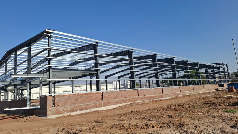 Pre-engineered building frame with purlins fixed above a brick perimeter wall